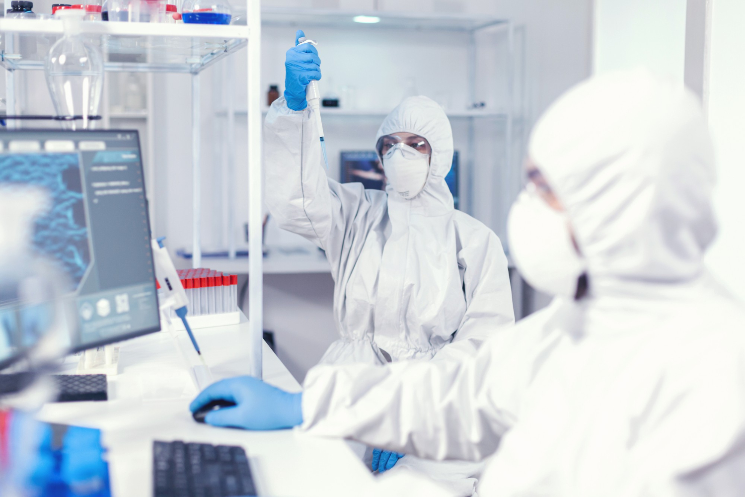 Cleanroom technician in full gown working at a laboratory bench